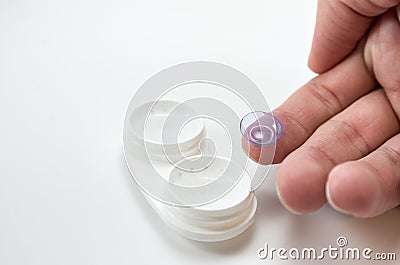 The Â man is holding a container for soft contact lenses and a lens on his finger, the concept of care Stock Photo